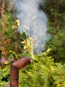smoke from rusty chimney outdoors