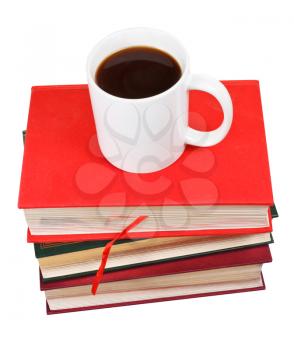 cup of coffee on stack of books isolated on white background