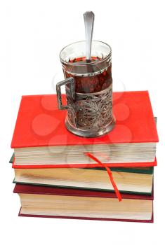 retro glass of tea on stack of books isolated on white background