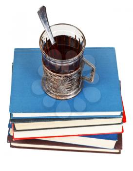 above view of glass of tea on stack of books isolated on white background