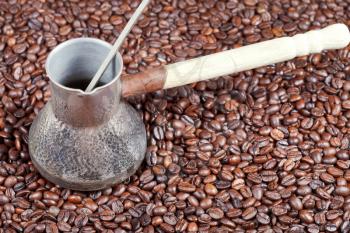 vintage coffee pot with spoon and many roasted coffee beans background