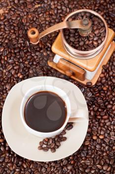 top view cup of coffee and roasted coffee beans with retro manual mill