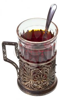 black tea in vintage glass with teaspoon and glass-holder isolated on white background