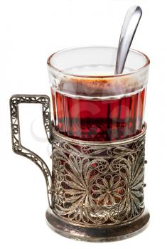 black tea in retro glass with teaspoon and glass-holder isolated on white background