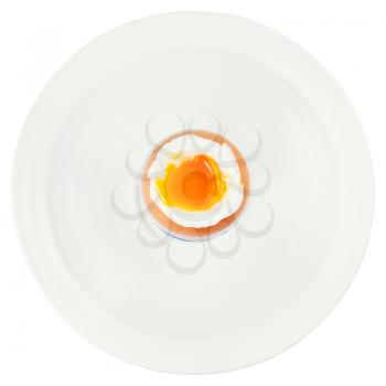 top view of soft boiled egg in egg cup on white plate isolated on white