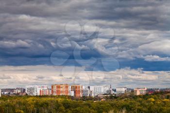 urban sky landscape with dark blue storm clouds over city in autumn