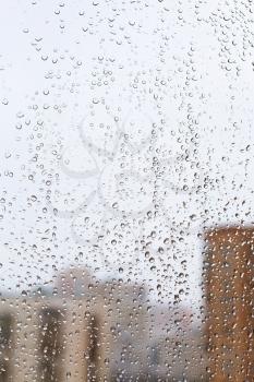 rain drops on glass window with city background