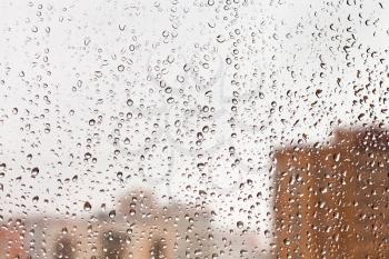 raindrops on glass window with cityscape background