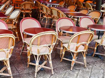 cane chairs and red table in paris outdoor cafe