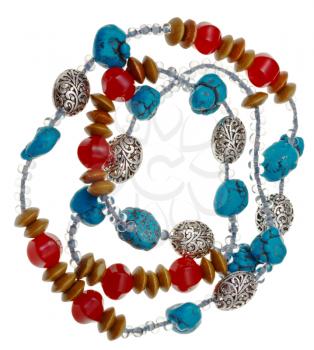 necklace from natural mineral beads of turquoise, wood, red jade stones, glass beads and carved metal isolated on white background