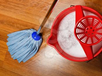 top view of mop and bucket with water for cleaning floors