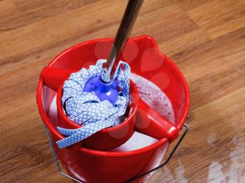 mop in red bucket with water for cleaning floors