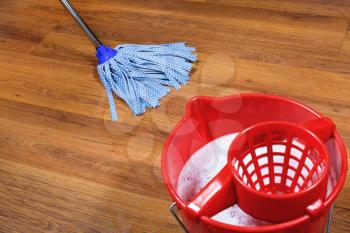 red bucket and mopping of parquet floors