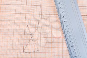 metal ruler at graph paper with dress pattern
