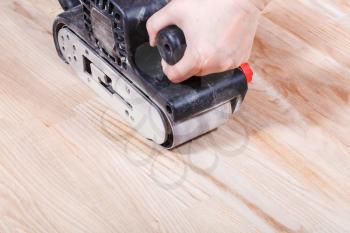 finishing ashwood surface by hand-held belt sander