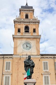 Giuseppe Garibaldi Monument with clock bell tower of Palazzo del Governatore on background in Parma, Italy