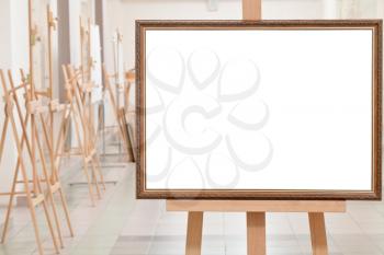 big picture frame with white cut out canvas on easel in gallery hall