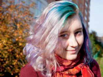 young woman with varicolored streaks hair outdoor in autumn day