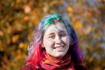 happy young woman with multicoloured streaks hair outdoor in autumn day