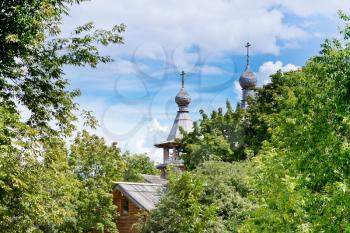 wooden church in green garden under blue sky