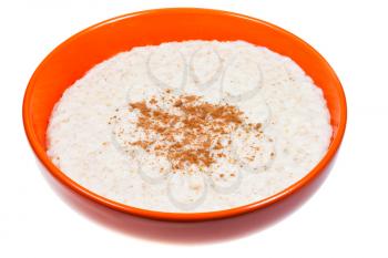 traditional english oat porridge with cinnamon in orange bowl isolated on white background