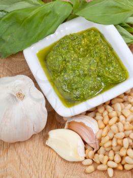 top view on italian pesto with ingredient on wooden board
