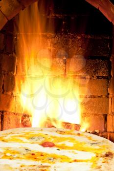 italian pizza and fire flames in wood burning oven