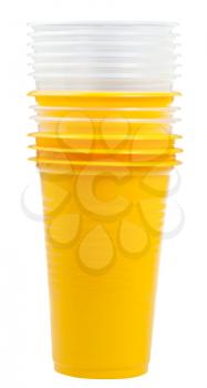 disposable tableware - stack of yellow and transparent plastic cups isolated on white background
