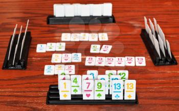set of tiles in rack during playing in rummy game on wooden board