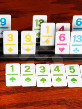 card rack - playing in rummy card game on wooden board