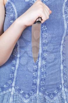 girl holding large kitchen knife in front of her
