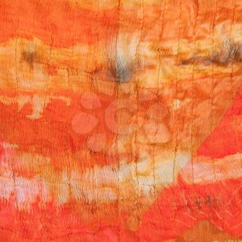 background from abstract painted orange silk batik close up