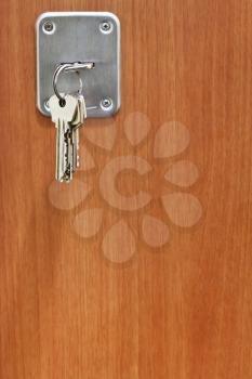 bunch of house keys in keyhole of wooden door