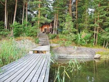 wooden bridge and small forest lake in Lakelands region of Finland