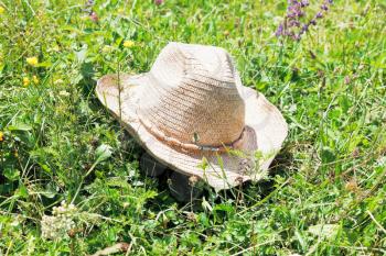 straw cowboy hat lying on green meadow