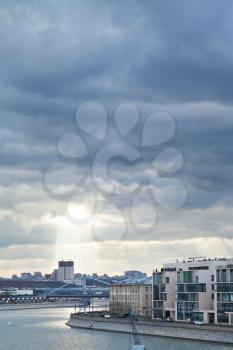 dark rainy clouds over Moskva River, Prechistenskaya embankment, and sunbeams illuminating Moscow building of the Russian Academy of Sciences in autumn evening