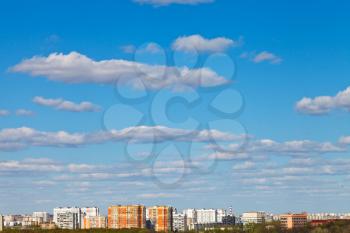 white clouds in blue sky over urban district in spring