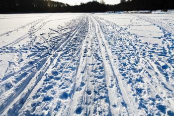 snowy field with ski runs in cold winter sunny day