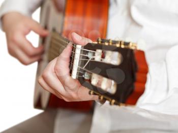 man plays on classical acoustic guitar close up isolated on white background
