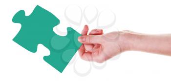 female hand with green puzzle piece isolated on white background