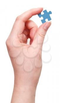 female hand holding blue puzzle piece isolated on white background