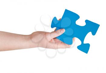 female hand holding big blue paper puzzle piece isolated on white background