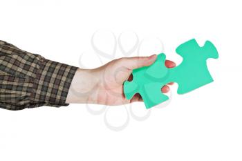 male hand holding big green paper puzzle piece isolated on white background