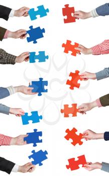 set of red and blue puzzle pieces in opposite sides in people hands isolated on white background