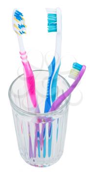three tooth brushes in glass - family set of toothbrushes isolated on white background