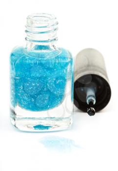 bottle with spilled turquoise nail polish on white background