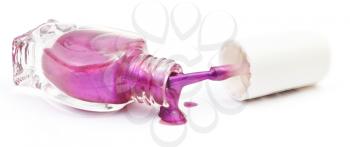 bottle and spilled purple nail polish on white background