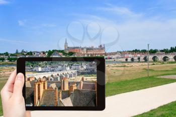 travel concept - tourist taking photo of Gien town in valley of Loire River on mobile gadget, France