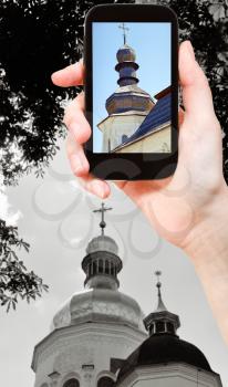 travel concept - tourist taking photo of church in Kiev of on mobile gadget, Ukraine