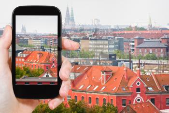 travel concept - tourist taking photo of Copenhagen city on mobile gadget, Denmark